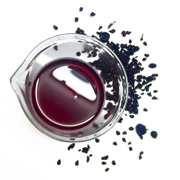 Deep dried purple grapes surround NATIVE EXTRACTS Grape Cellular Extract deep red in colour in a beaker
