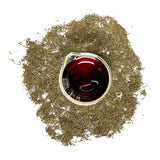 Thyme leaves (Thymus vulgaris), are small, green, and clustered on stems, and are used to create the Native Extracts Thyme Cellular Extract.   Dried Thyme leaves (Thymus vulgaris), surround a beaker of Native Extracts Thyme Cellular Extractt, which is deep red in colour.