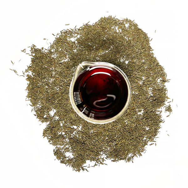 Thyme leaves (Thymus vulgaris), are small, green, and clustered on stems, and are used to create the Native Extracts Thyme Cellular Extract.   Dried Thyme leaves (Thymus vulgaris), surround a beaker of Native Extracts Thyme Cellular Extractt, which is deep red in colour.