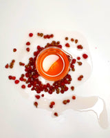 The Lilli Pilli-Riberry Cellular Extract in a beaker, surrounded by Lilli Pilli-Riberry.